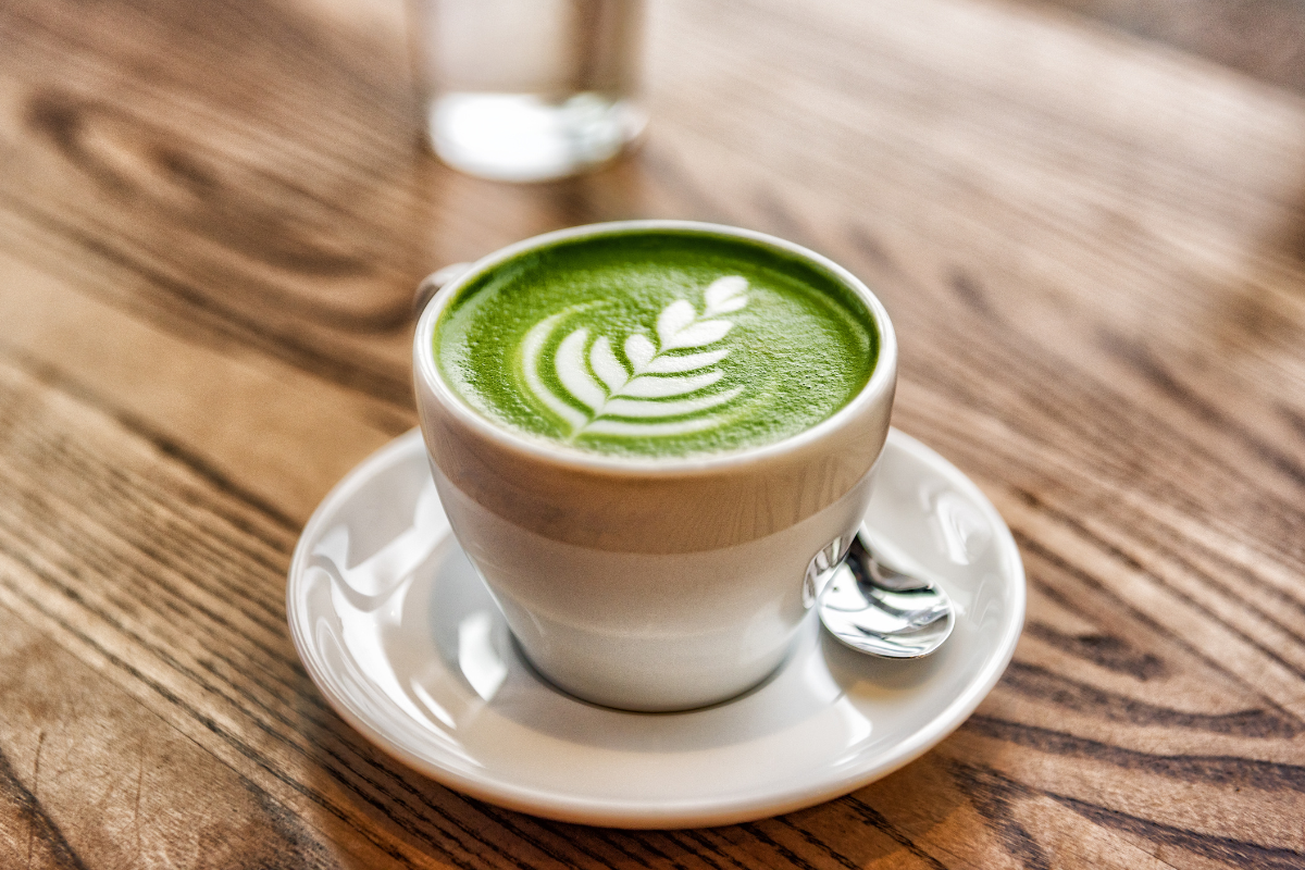 Tasse de café infusé au CBD avec une mousse verte, mélangeant détente et saveurs pour un effet anti-stress