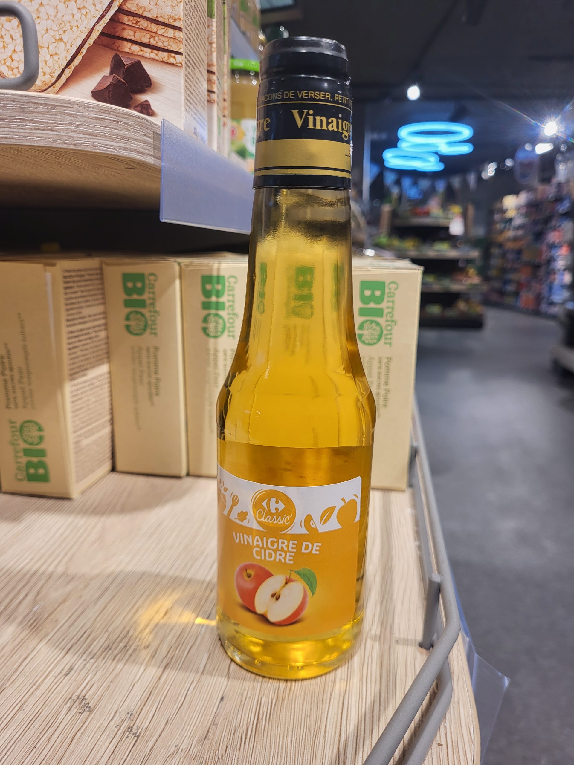 Bouteille de vinaigre de cidre de pomme en magasin bio, mettant en avant ses propriétés naturelles et ses bienfaits pour la santé.