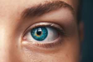 Gros plan sur un œil bleu, illustrant les effets de la mélatonine sur la vision et ses bienfaits pour la santé oculaire.