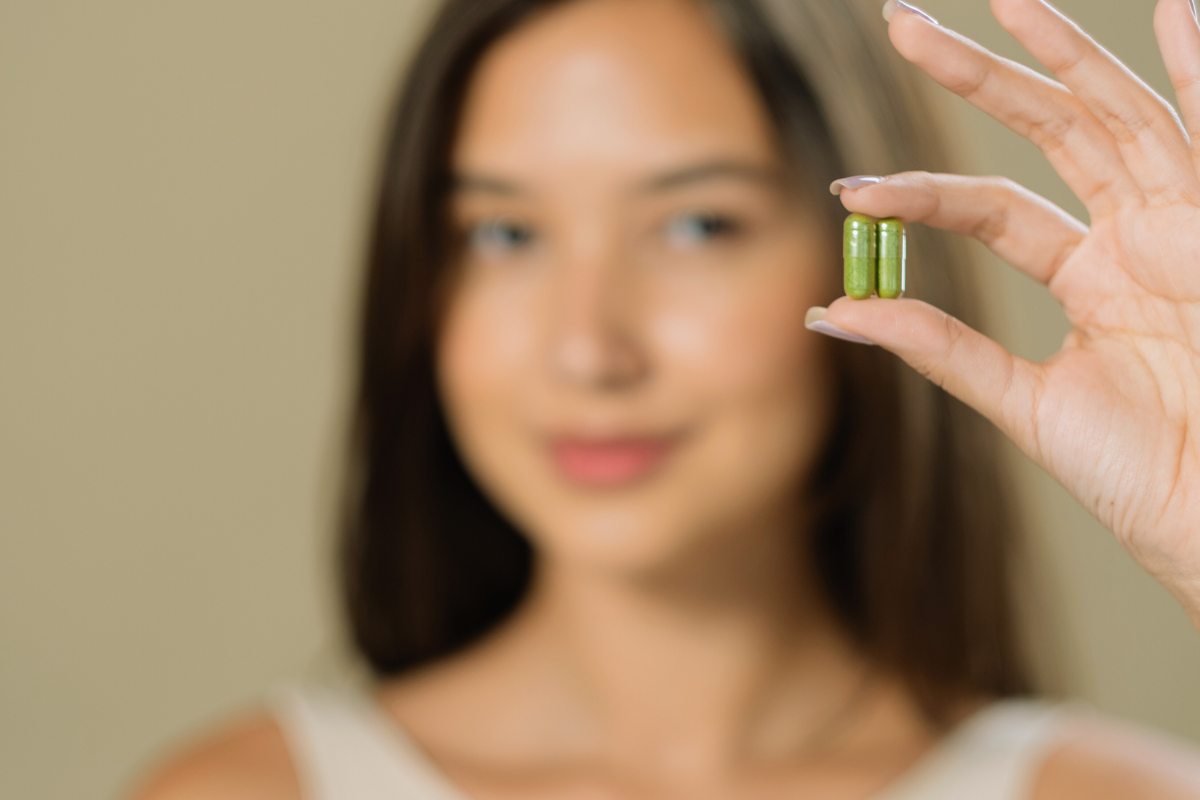 Femme présentant des gélules de Ginkgo Biloba, reconnues pour leurs bienfaits sur la mémoire et la concentration