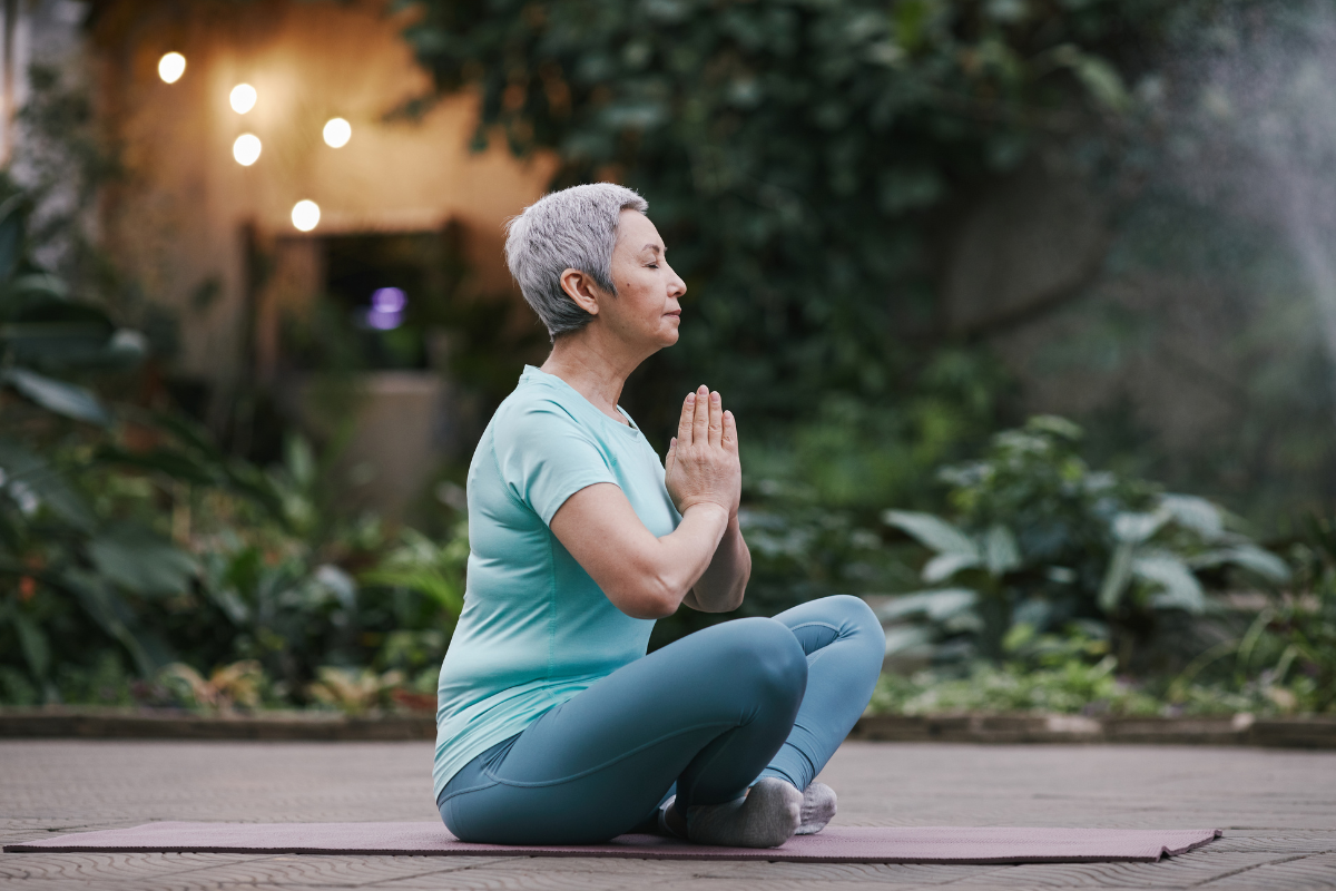 Femme méditant en pleine nature, combinant yoga et CBD pour apaiser le stress.