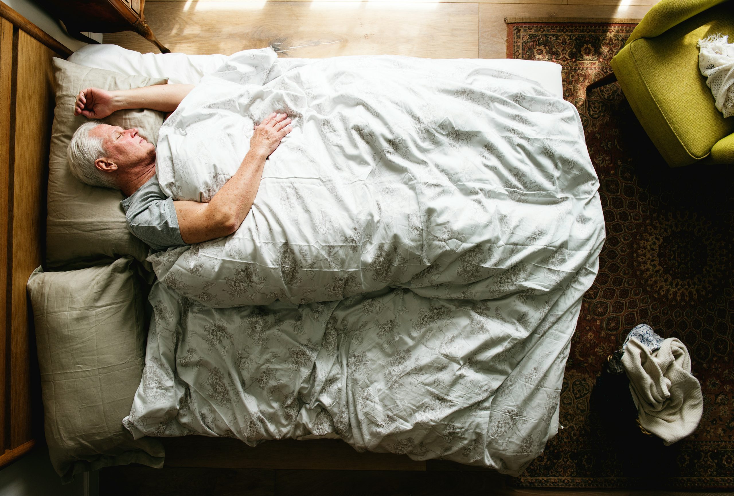 Personne âgée dormant paisiblement sur son lit.