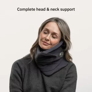 Femme utilisant un oreiller de voyage Trtl gris, offrant un soutien complet de la tête et du cou.
