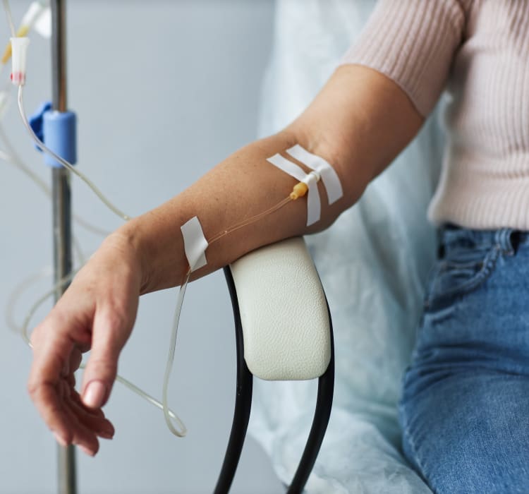 Perfusion intraveineuse vitaminée IV Drip administrée à une patiente assise, en soin revitalisant.