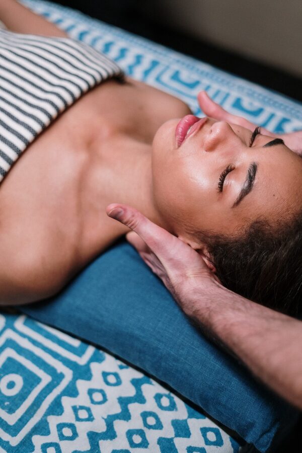 Femme allongée recevant un massage facial relaxant type Kobido dans un institut de bien-être.