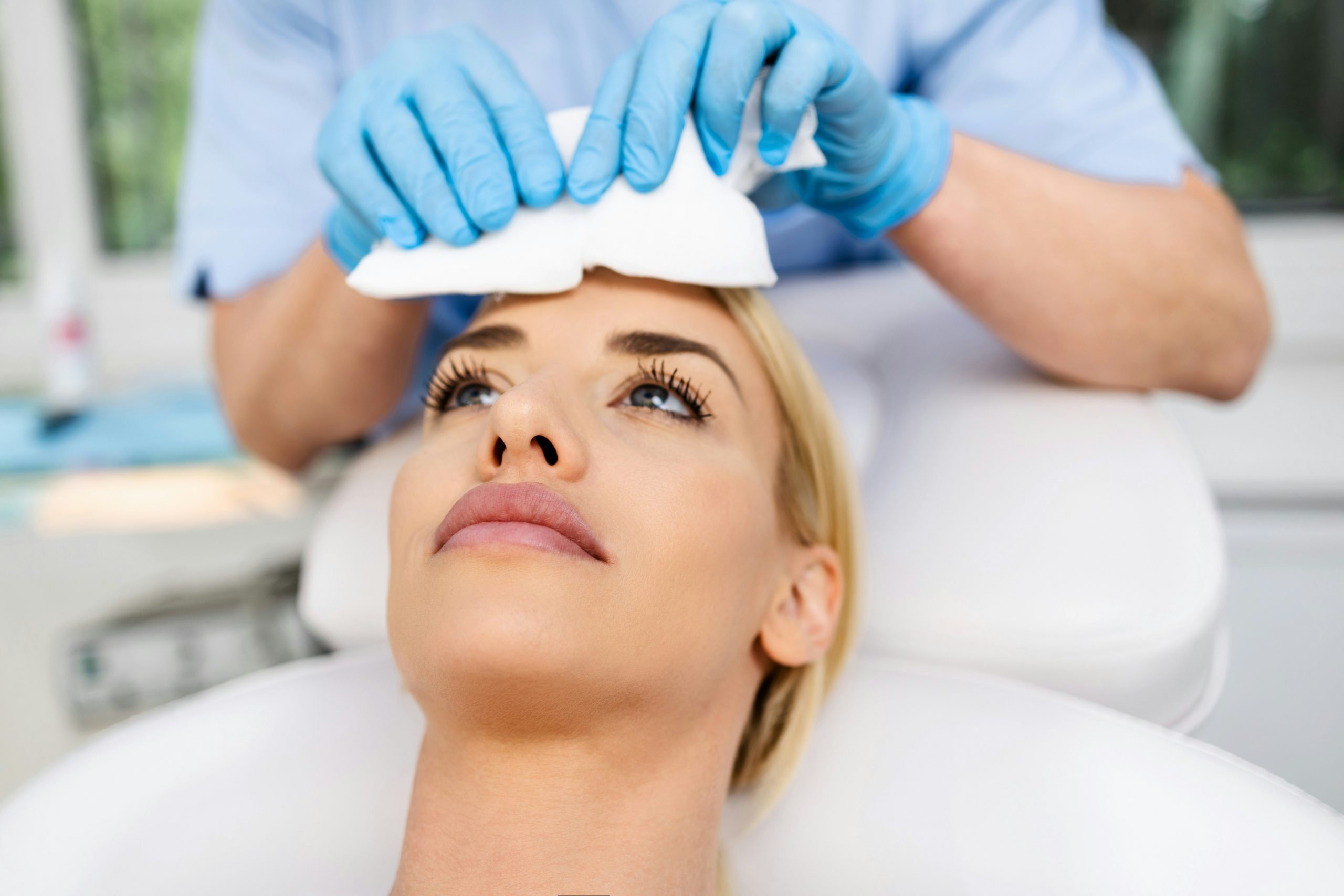 Femme recevant un soin de microneedling du visage dans un institut esthétique.